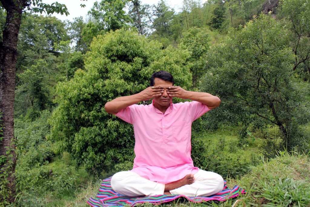 Breathing Techniques in Yoga: The Foundation of Physical and Mental Well-Being Man practicing yoga in serene Nepalese park, promoting mindfulness.